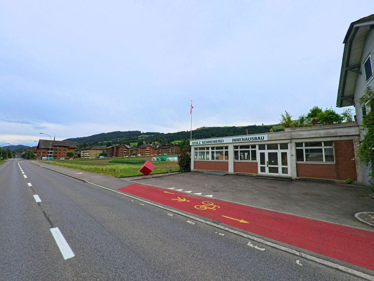 In Malters (6002, Kanton Luzern) befindet sich ein Gewerbegebäude mit der Aufschrift „Stulz Schreinerei Innenausbau“ direkt an einer Hauptstrasse mit Fahrradstreifen.
