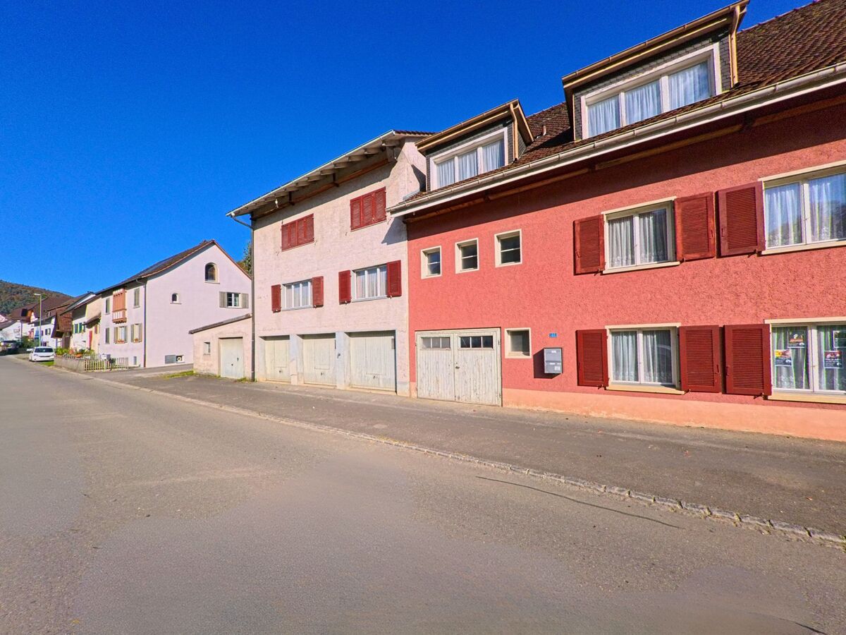 Eine Strasse mit farbigen Wohnhäusern prägt das Ortsbild von Merishausen (8232, Kanton Schaffhausen).