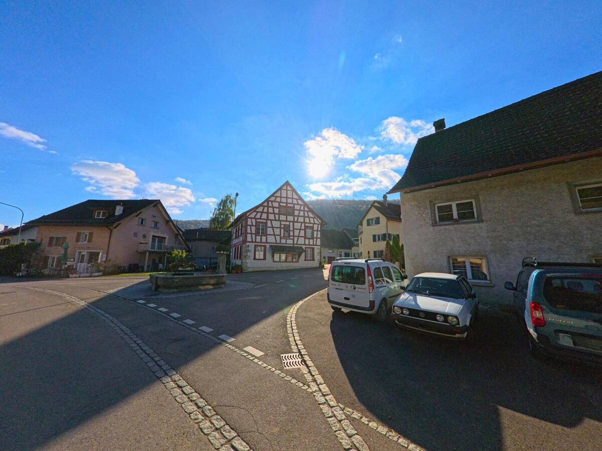 An einer engen Strassenkreuzung stehen Wohnhäuser im Dorfkern von Merishausen (8232, Kanton Schaffhausen).
