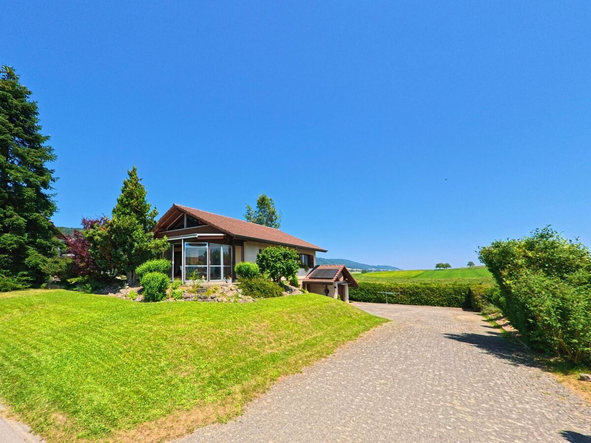 In Messen (3254, Kanton Solothurn) liegt ein freistehendes Einfamilienhaus mit Wintergarten auf einem gepflegten Grundstück mit Ausblick über Felder und Hügel.
