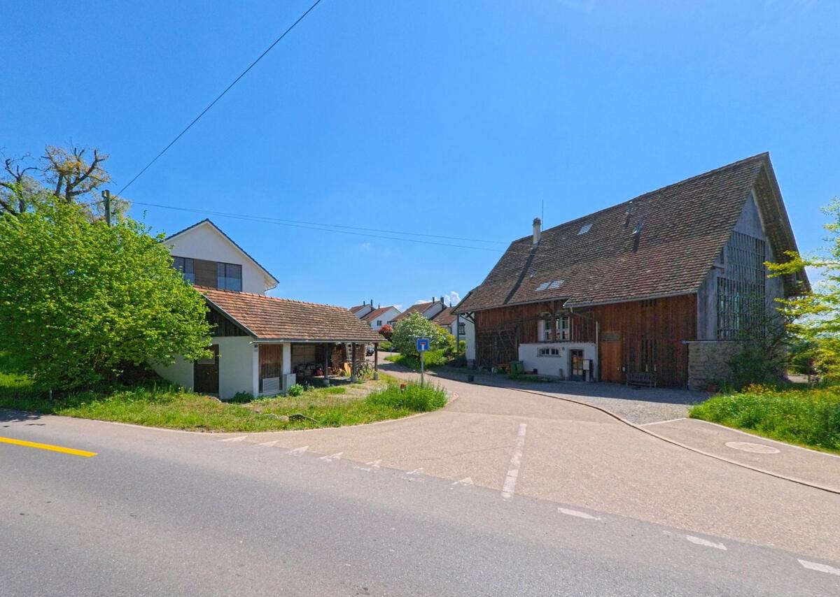 Am Rand von Mettmenstetten, PLZ 8932 im Kanton Zürich zweigt eine Sackgasse mit Bauernhaus und Wohngebäuden von der Hauptstrasse ab.