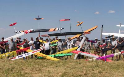 Die Mitglieder der MFG-Balsthal posieren mit zahlreichen farbigen Modellflugzeugen auf einer Wiese in Balsthal (4710, Kanton Solothurn).