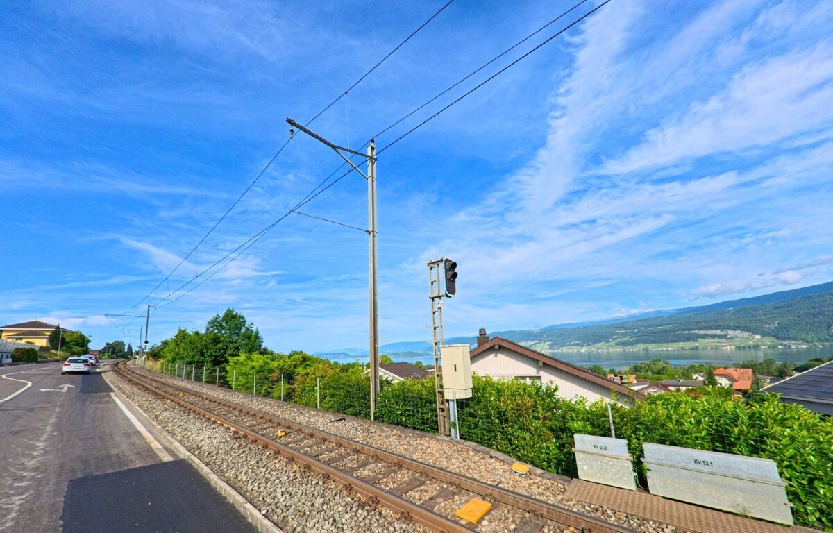 In Mörigen (2572, Kanton Bern) verläuft die Bahnlinie parallel zur leicht ansteigenden Strasse mit Blick auf den Bielersee und die bewaldeten Hügel des Juras.