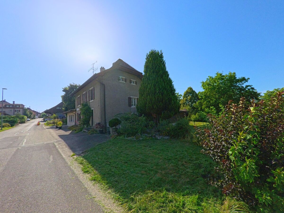 Ein Wohnhaus mit angrenzendem Garten und grossen Baeumen liegt in Molondin (1415, Kanton Waadt) an einer ruhigen Strasse.