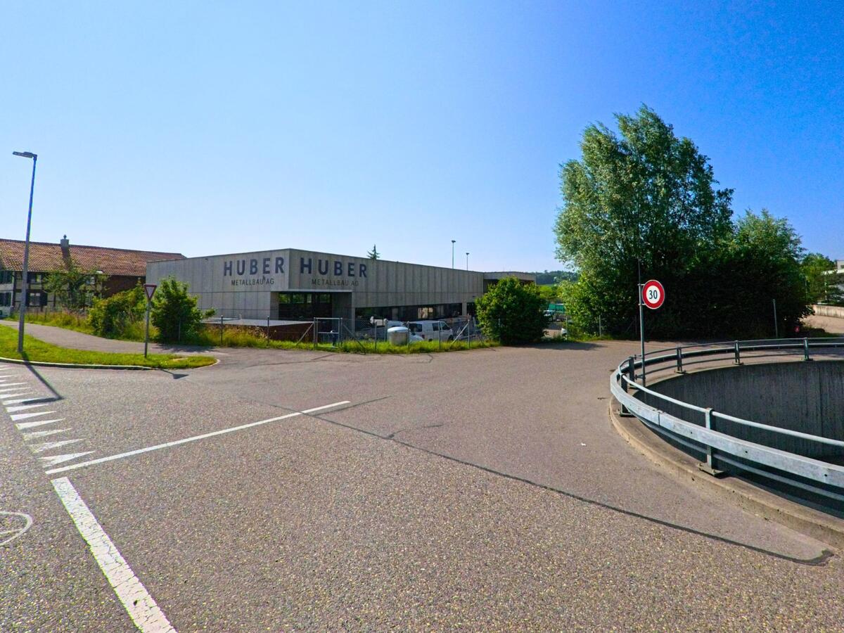 Im Industriegebiet von Moosseedorf (3321, Kanton Bern) befindet sich ein Metallbaubetrieb mit grossen Hallen neben einer Zufahrtsrampe und vereinzelten Bäumen.