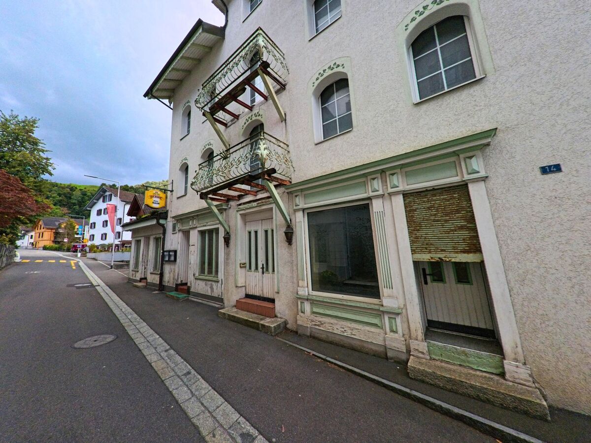 Ein historisches Gebäude mit dekorativer Fassade steht an einer schmalen Gasse in Morschach (6443, Kanton Schwyz).