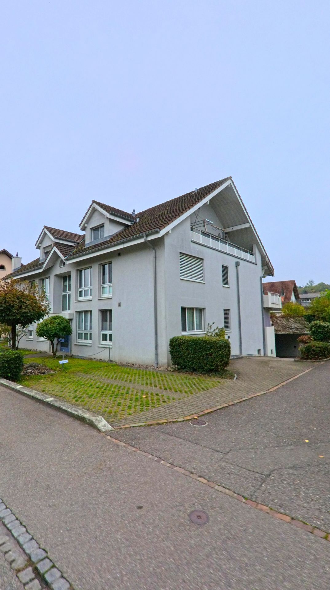 Ein modernes Mehrfamilienhaus in Mülligen (5243, Kanton Aargau) mit grossen Fenstern und gepflegtem Vorplatz steht in einer ruhigen Wohngegend.