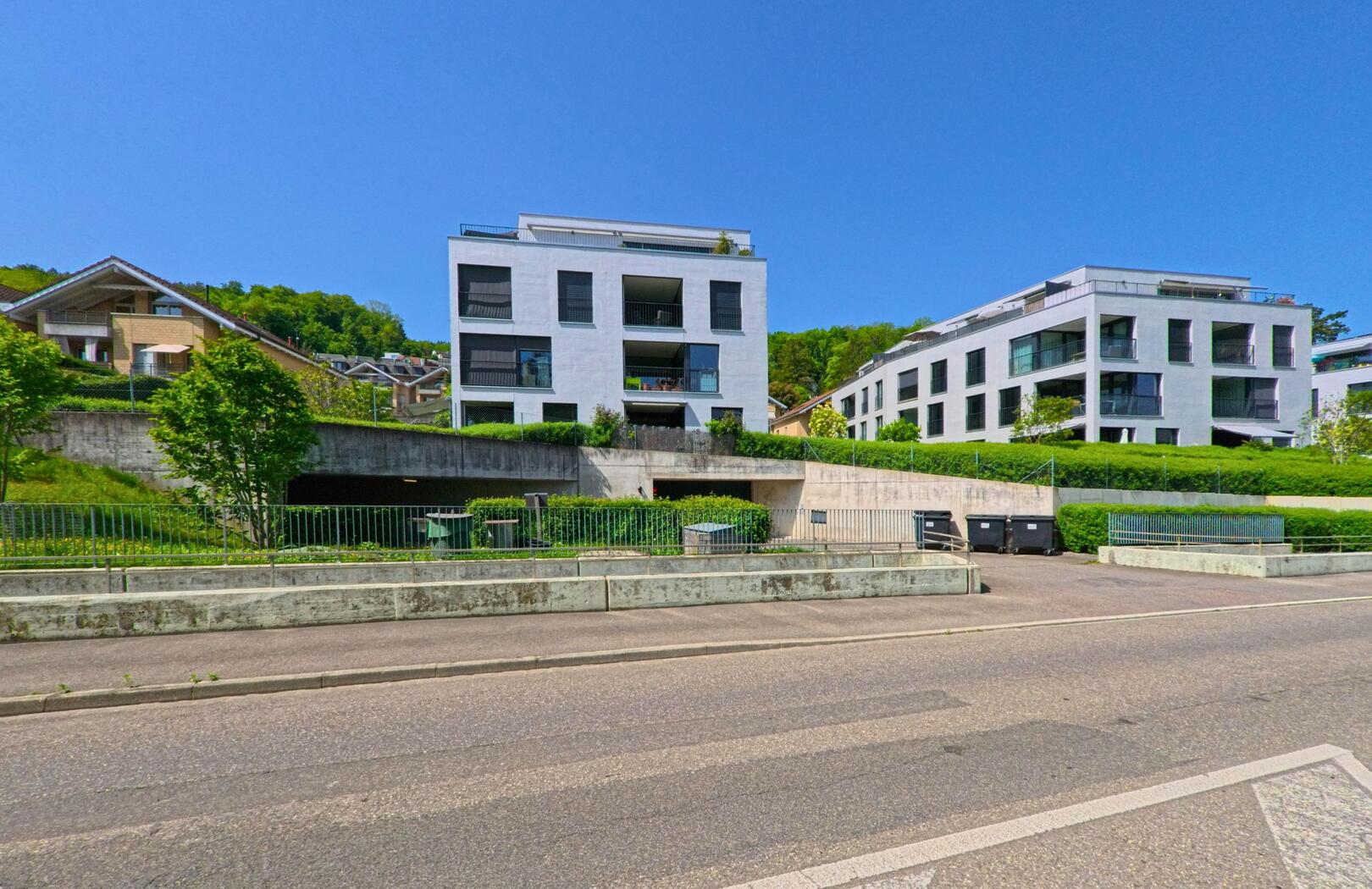 Moderne Wohnbauten mit grosszügigen Balkonen prägen in Münchenstein (4142, Kanton Basel-Landschaft) das Bild eines neu entwickelten Wohnquartiers am Hang.