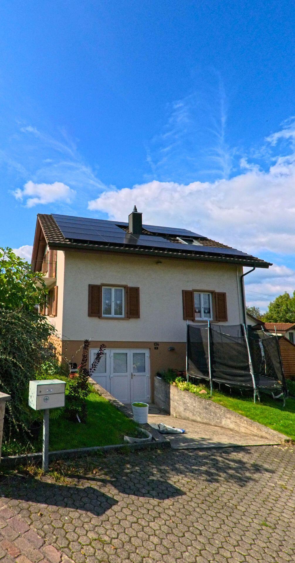 Ein Einfamilienhaus mit Solarpanelen auf dem Dach steht in Münchwilen (4333, Kanton Aargau) an einer gepflasterten Einfahrt mit Garten und Briefkasten.