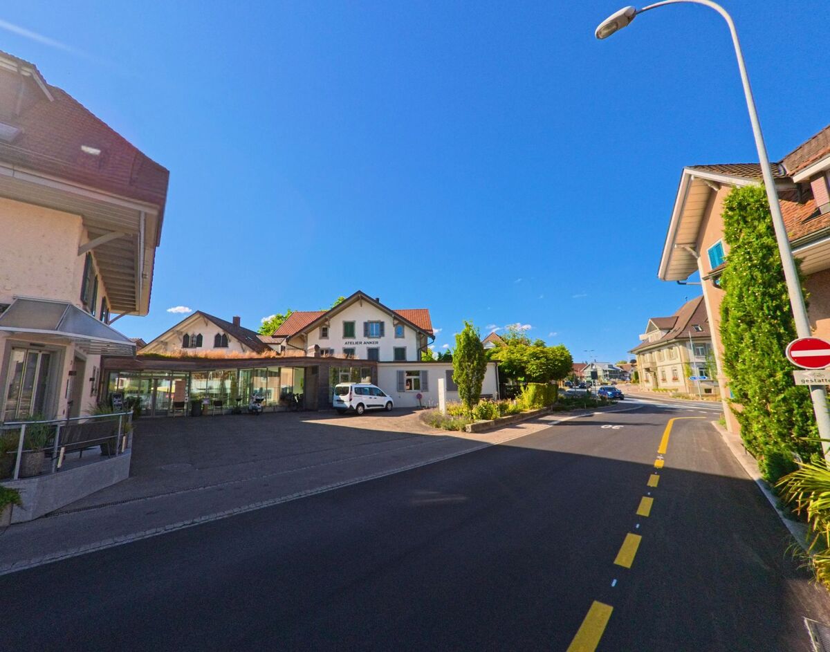 In Münsingen (3110, Kanton Bern) befindet sich das Atelier Anker in einem hellen Gebäude mit roten Ziegeldächern entlang einer Einbahnstrasse im Wohnquartier.