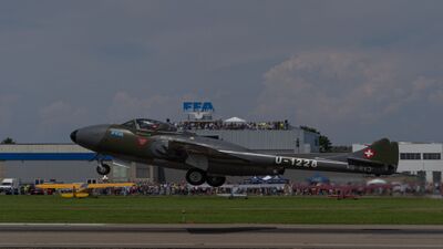 Vor dem Museum Altenrhein in Thal (9423, Kanton St. Gallen) hebt ein historisches Militärflugzeug mit Schweizer Hoheitszeichen während einer Flugvorführung ab.