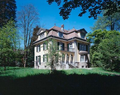 Das Museum im Bellpark in Kriens (6011, Kanton Luzern) befindet sich in einer eleganten Villa mit Garten, umgeben von hohen Bäumen.