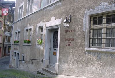 In Laufenburg (5080, Kanton Aargau) befindet sich das Museum Schiff in einem historischen Gebaeude mit heller Fassade, schmiedeeiserner Tuer und Fensterkaesten voller Blumen.