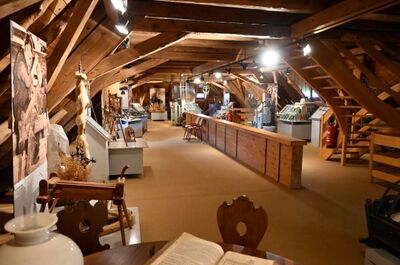 Unter dem Dachstuhl eines historischen Gebäudes in Schleitheim (8226, Kanton Schaffhausen) zeigt eine Ausstellung alte Werkzeuge und landwirtschaftliche Geräte.