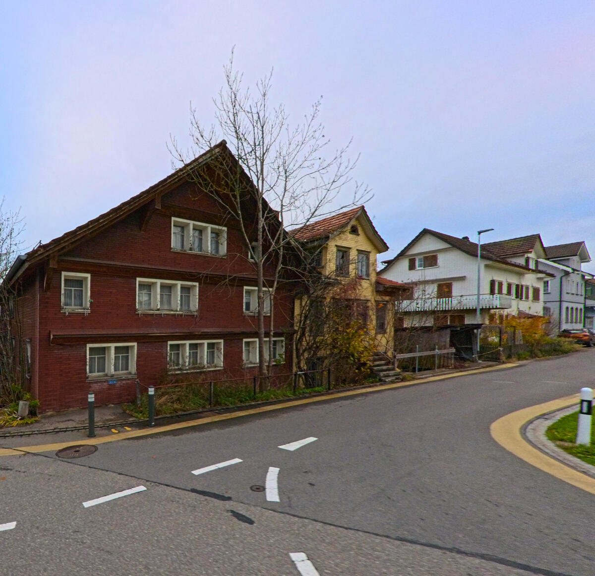 Ein traditionelles Holzhaus steht an einer geschwungenen Strasse im Ort Neckertal (9122, Kanton St. Gallen).
