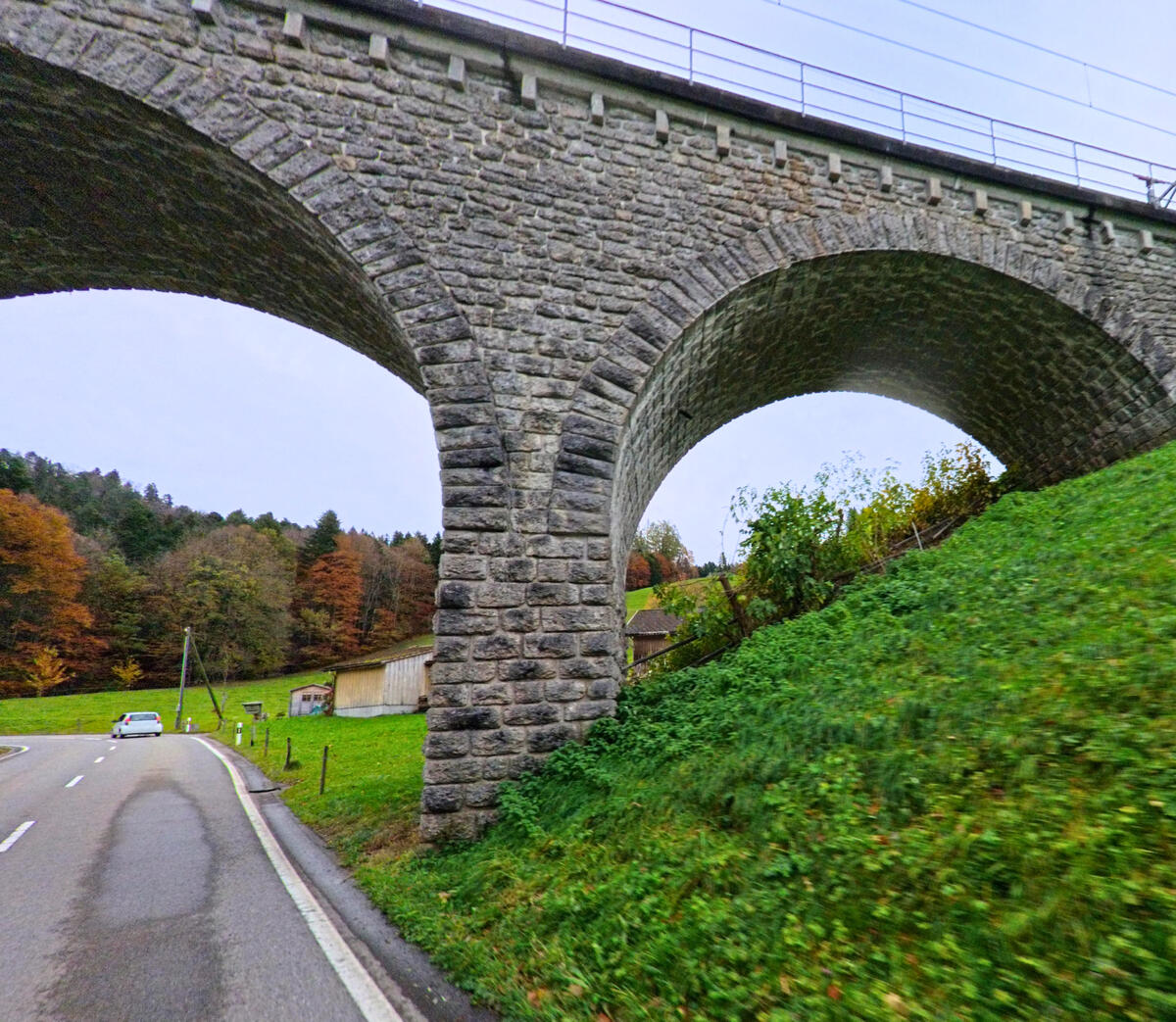 Ein Steinviadukt ueberspannt einen Weg am Gruenrand von Neckertal (9122, Kanton St. Gallen).