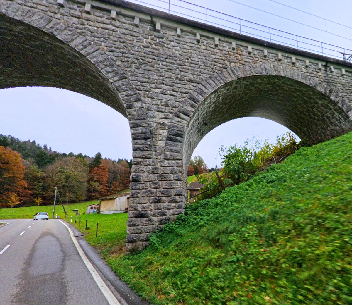 Ein Steinviadukt ueberspannt einen Weg am Gruenrand von Neckertal (9122, Kanton St. Gallen).