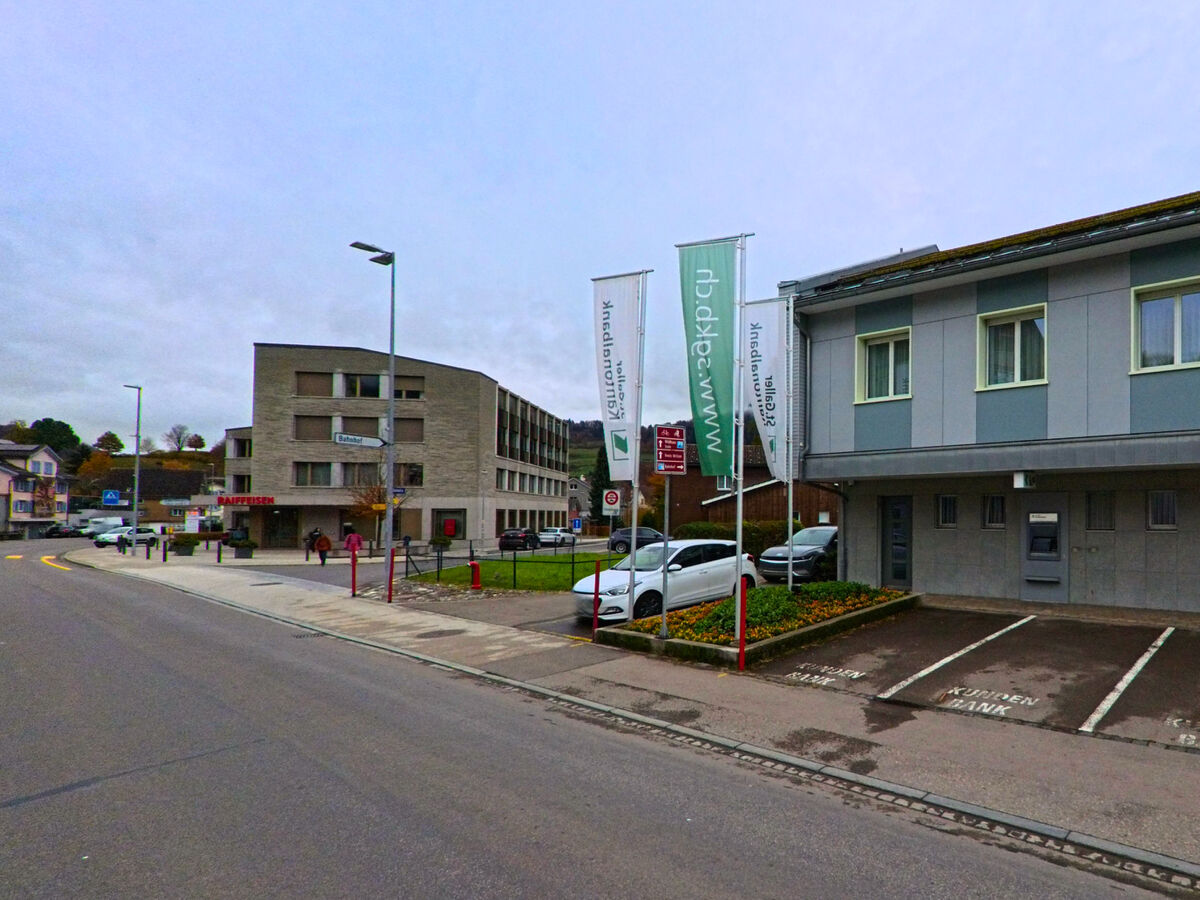 Moderne Gebaeude mit Parkplaetzen praegen einen Abschnitt der Strasse in Nesslau (9650, Kanton St. Gallen).