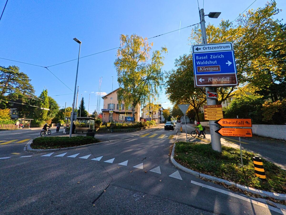 An einer Strassenkreuzung weisen Schilder den Weg durch Neuhausen am Rheinfall (8212, Kanton Schaffhausen).
