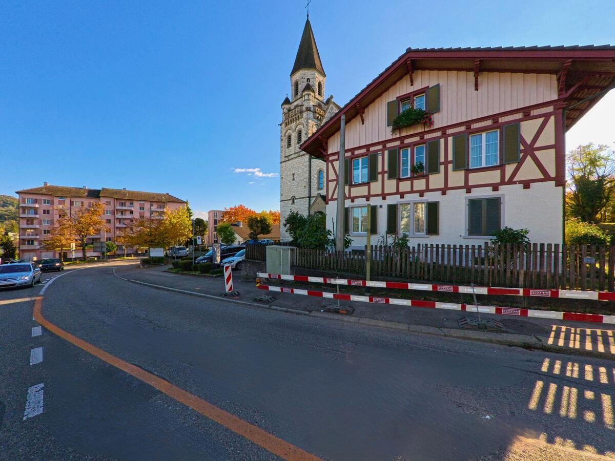 An einer Hauptstrasse stehen historische Gebäude mit Kirche im Ortszentrum von Neuhausen am Rheinfall (8212, Kanton Schaffhausen).