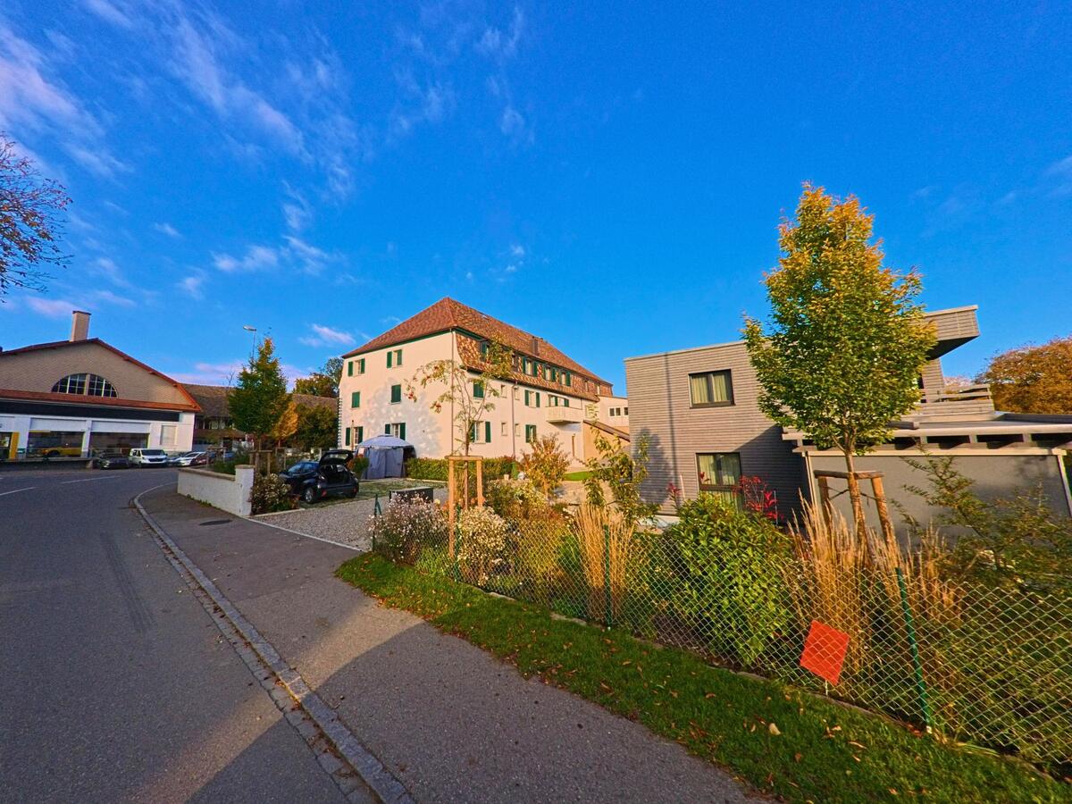 Zwischen Wohnhäusern und Gärten verläuft eine Quartierstrasse in Neunkirch (8213, Kanton Schaffhausen).