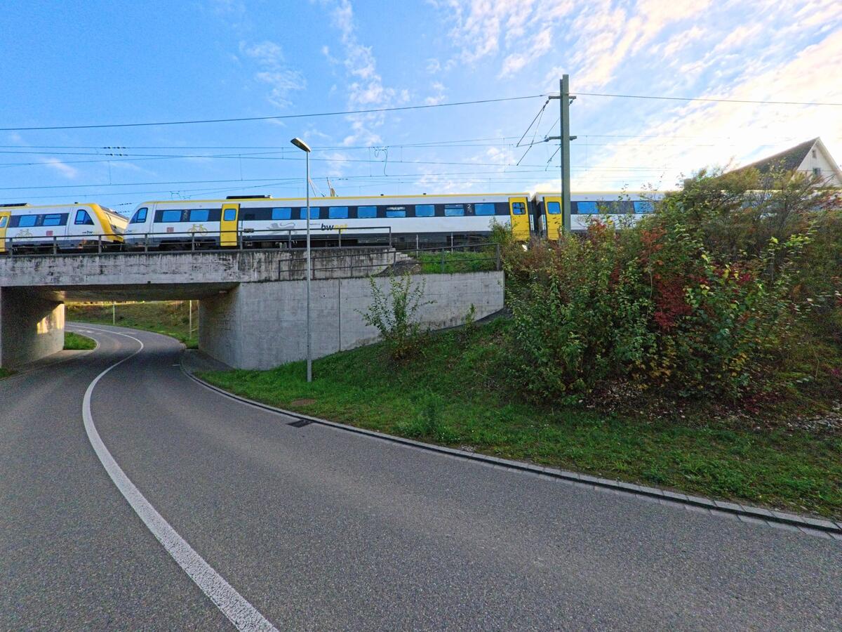Unter einer Bahnlinie verläuft die Strasse entlang einer Böschung in Neunkirch (8213, Kanton Schaffhausen).