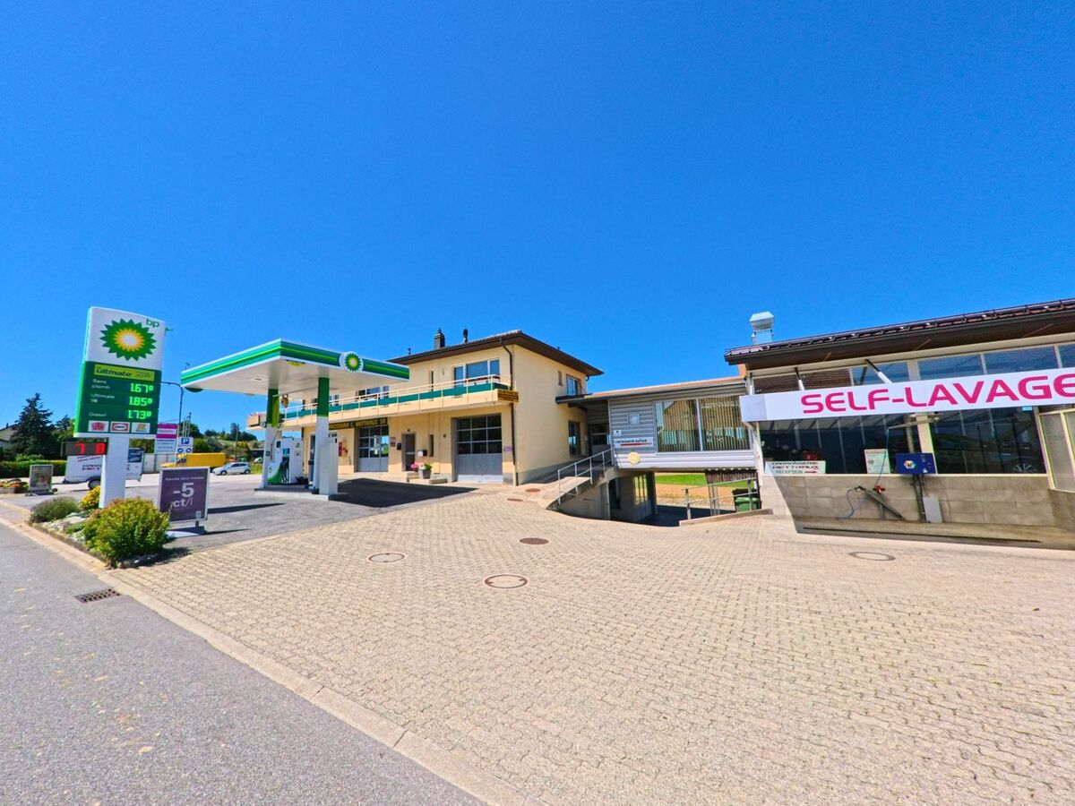 Eine BP-Tankstelle mit angeschlossener Selbstwaschanlage steht in Neyruz (1740, Kanton Freiburg) an einer breiten Zufahrtsstrasse.