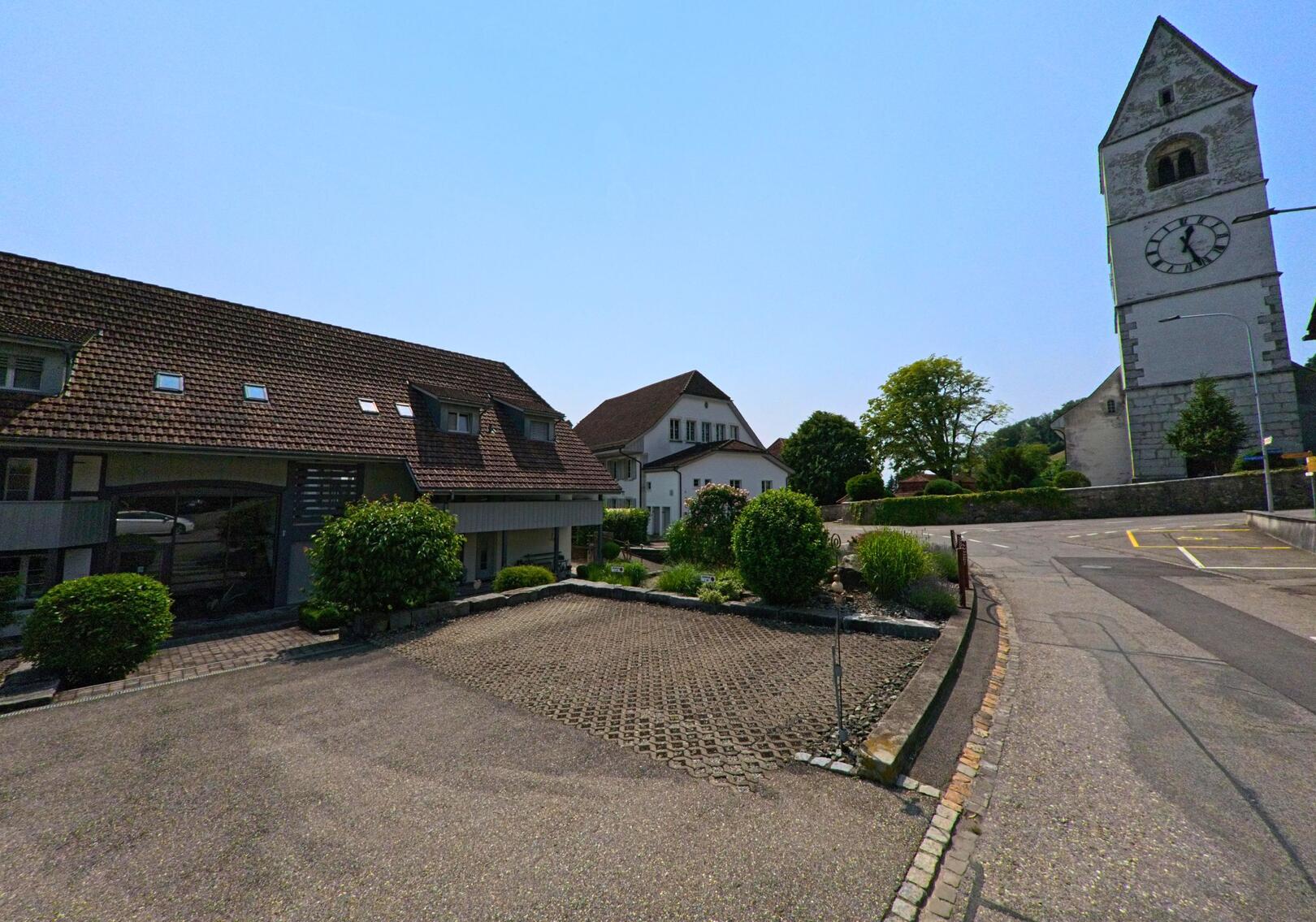 In Oberbipp (4538, Kanton Bern) steht die reformierte Kirche mit ihrem markanten Uhrturm neben gepflegten Wohnhäusern und einer ruhigen Strassenszene.