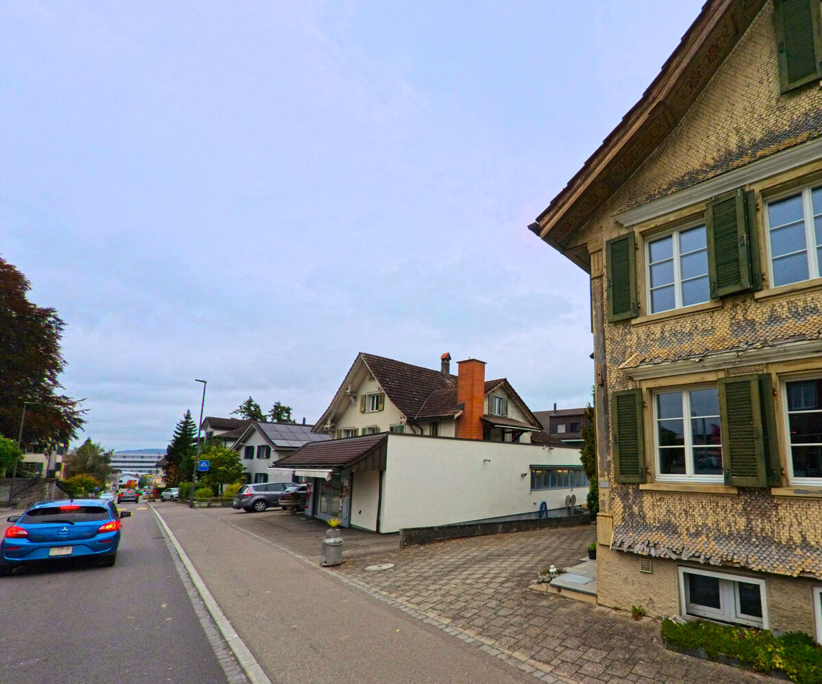 Die Ortsstrasse fuehrt an aelteren Wohngebaeuden vorbei durch Oberbueren (9245, Kanton St. Gallen).