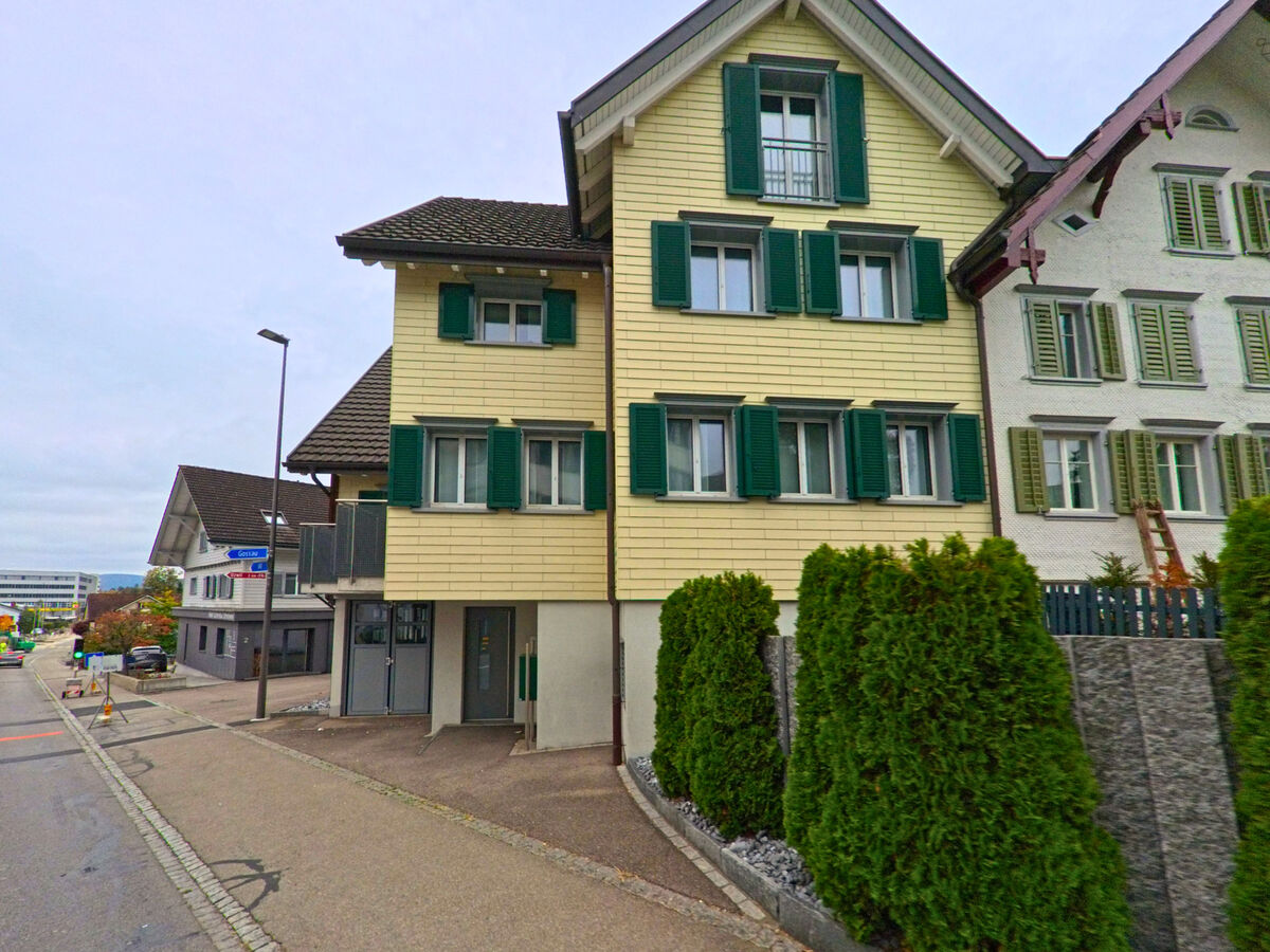 Ein Wohnhaus mit gruener Fassade steht an einer Nebenstrasse im Ortskern von Oberbueren (9245, Kanton St. Gallen).