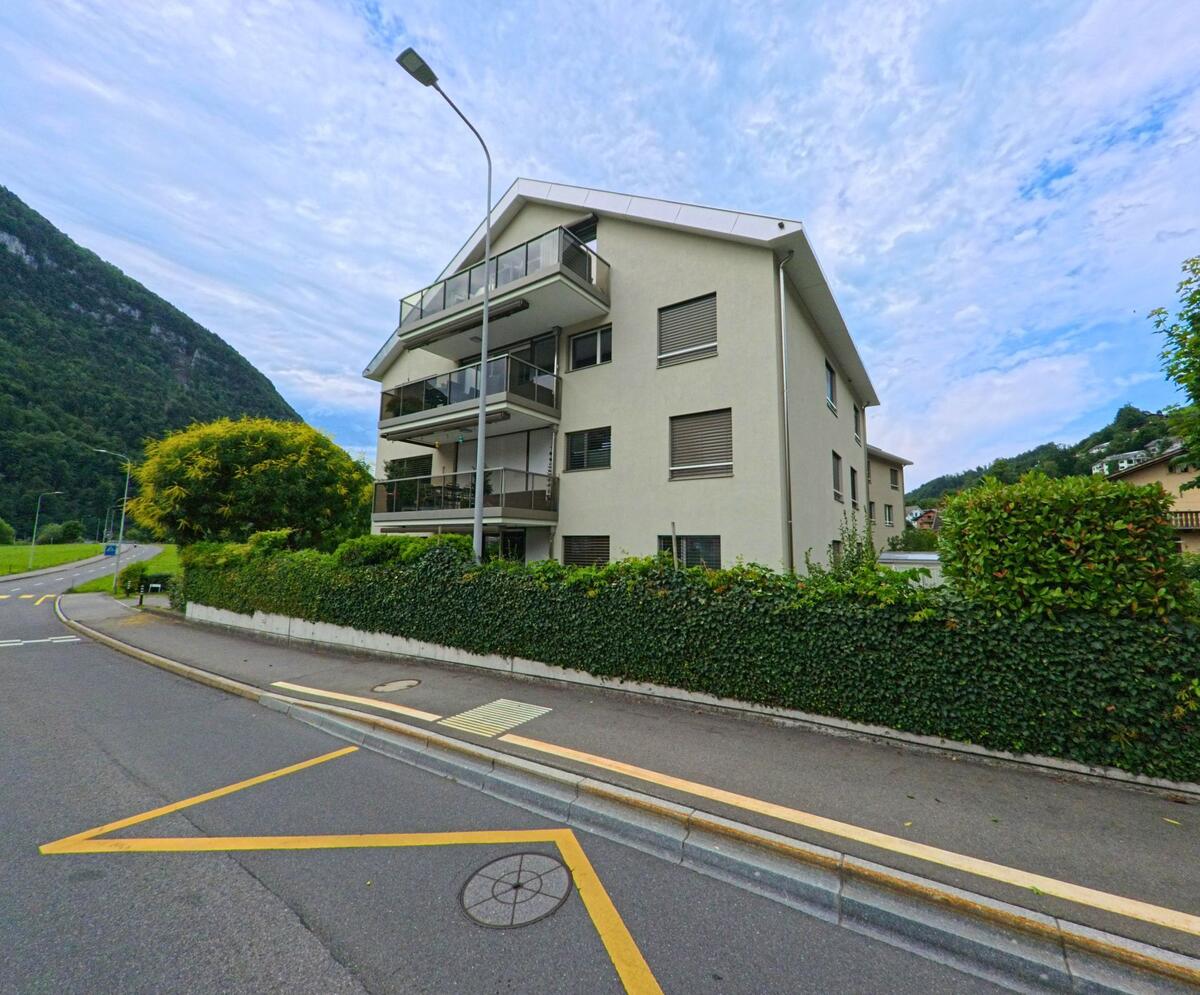 In Oberdorf (6382, Kanton Nidwalden) steht ein helles Mehrfamilienhaus mit grossen Balkonen an einer ruhig gelegenen Kurve am Fusse eines bewaldeten Hangs.