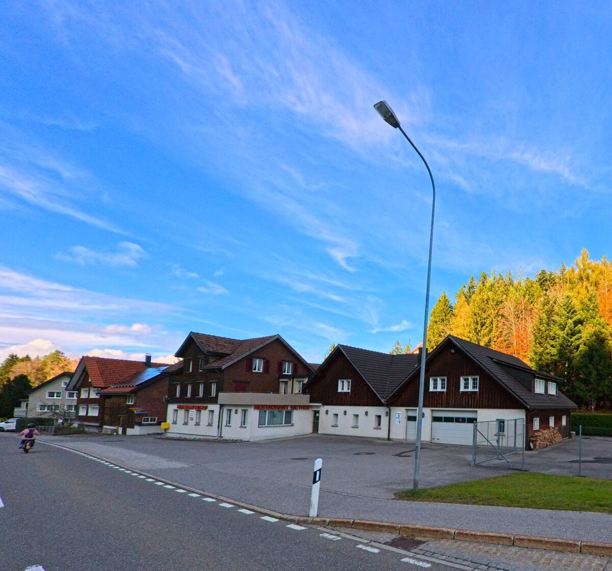 Traditionelle Wohnhäuser gruppieren sich entlang einer breiten Strasse in Oberegg (9413, Kanton Appenzell Innerrhoden).