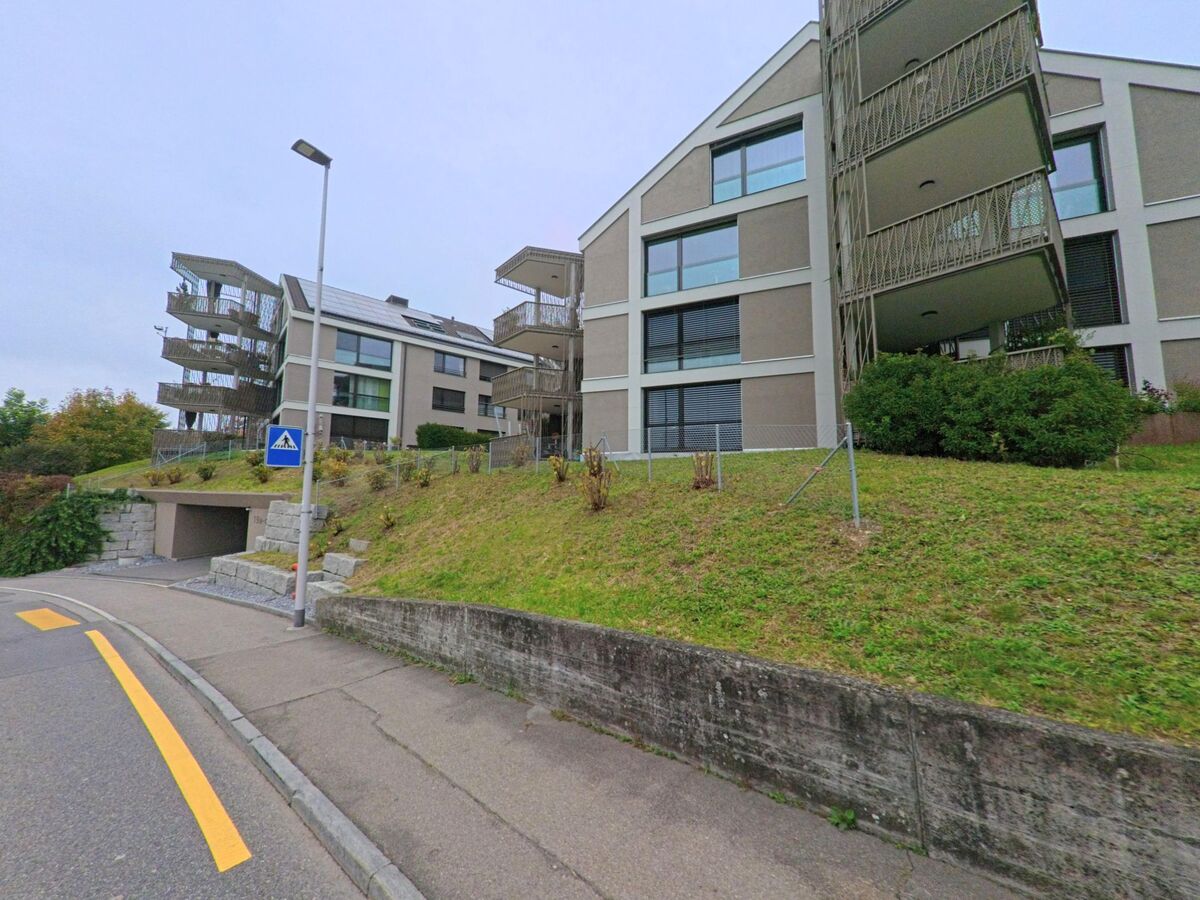 Mehrere moderne Wohngebaeude mit grossen Fenstern und Balkonen stehen an einem leicht ansteigenden Hang in Oberlunkhofen (8917, Kanton Aargau).