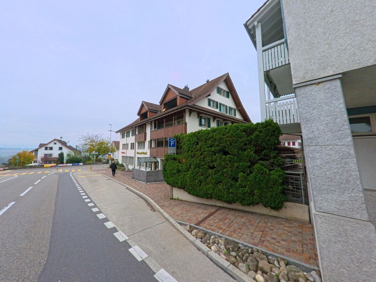 Ein traditionsreiches Gebaeude mit Restaurant und Holzbalkonen steht an einer leicht ansteigenden Strasse in Oberlunkhofen (8917, Kanton Aargau).