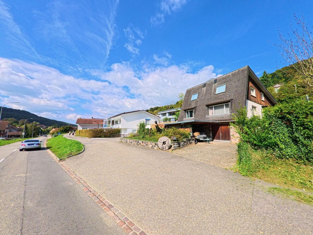 Am sonnigen Hang von Obermumpf (4324, Kanton Aargau) stehen Einfamilienhaeuser mit grossen Einfahrten und Blick auf die umliegenden Huegel.