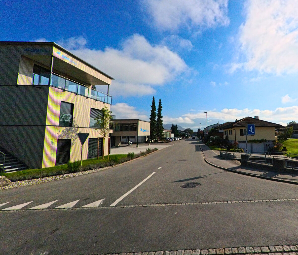 Eine moderne Strasse mit klarer Linienfuehrung verlaeuft durch Oberriet (9463, Kanton St. Gallen).