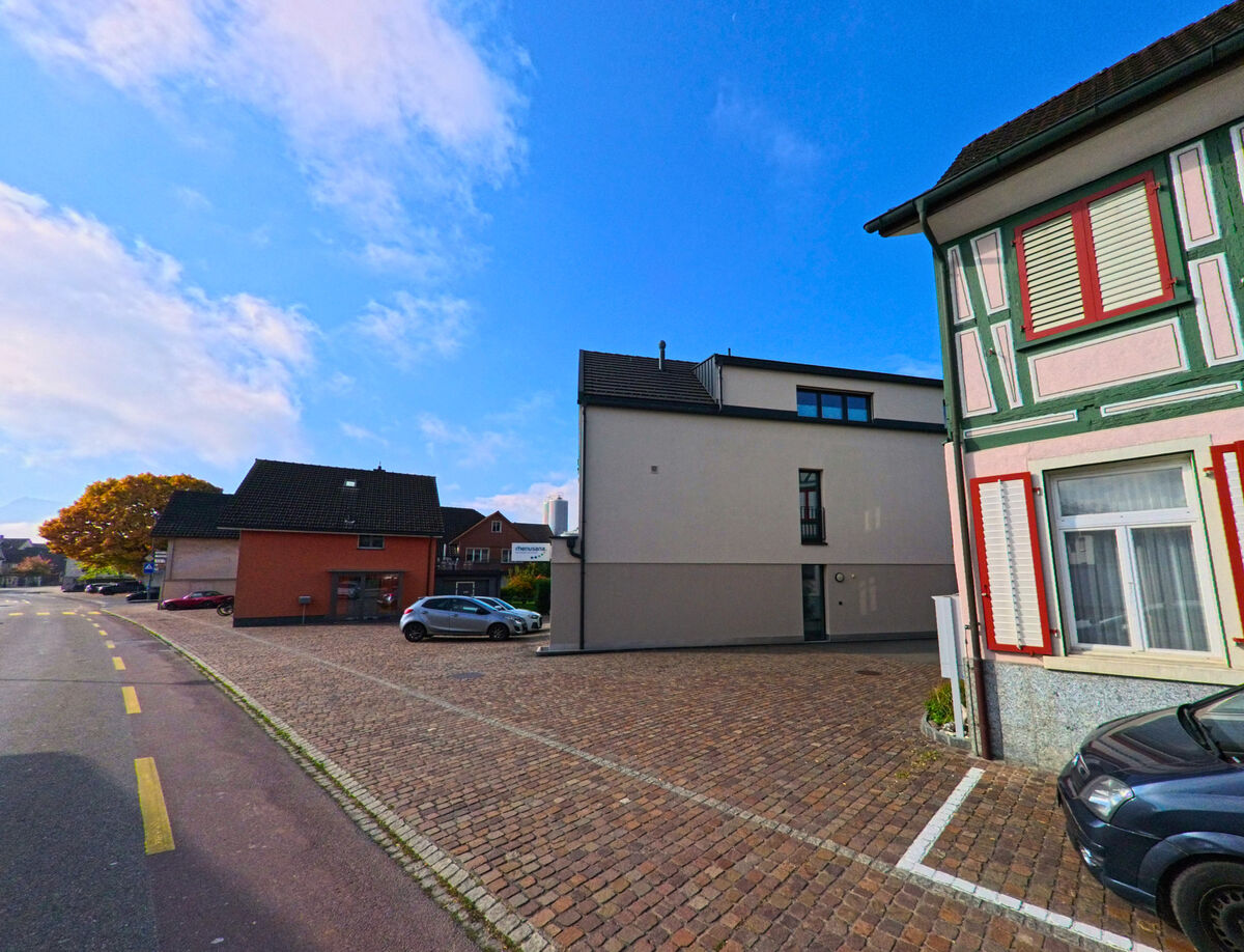 Ein gepflasterter Platz zwischen Gebaeuden bildet einen ruhigen Bereich in Oberriet (9463, Kanton St. Gallen).