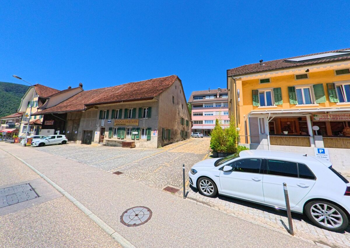 In Oensingen (4702, Kanton Solothurn) reihen sich entlang einer gepflasterten Gasse historische Gebäude mit Brockenstube und Gastronomiebetrieb aneinander.