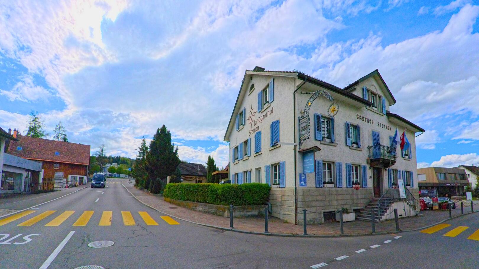 Im Zentrum von Oetwil am See im PLZ-Gebiet 8618 des Kantons Zürich steht der historische Gasthof Sternen an einer verkehrsberuhigten Kreuzung mit Zebrastreifen.