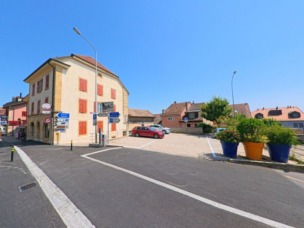 In Orbe (1350, Kanton Waadt) kontrolliert ein Kammerjaeger die Fassade eines Hauses mit roten Fensterlaeden an einer Strassenecke nahe dem Stadtzentrum.