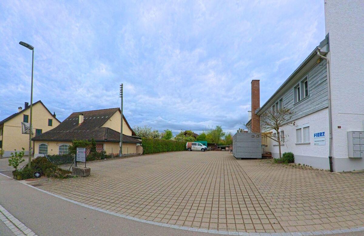 In Ossingen, PLZ 8475 im Kanton Zürich, liegt ein gepflasterter Firmenhof mit Werkstattgebäuden und einem Fahrzeug der Firma Fierz.