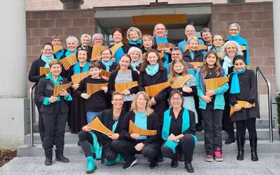 Mitglieder einer Panfloetengruppe stehen in Langnau am Albis 8135 im Kanton Zurich vor einem Gebaeude und halten ihre Instrumente fuer ein Gruppenfoto in den Haenden.
