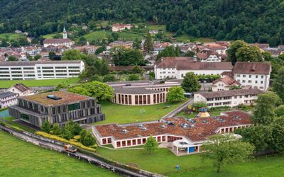 Ein Schul und Wohnareal mit mehreren Gebaeuden liegt eingebettet in gruene Landschaft in Altdorf (6460, Kanton Uri) und zeigt eine ruhige Umgebung.
