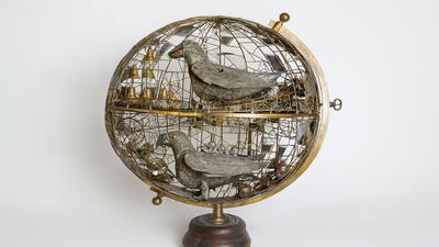 Im Paul Gugelmann Museum in Schönenwerd (5012, Kanton Solothurn) zeigt ein kunstvoll gestaltetes mechanisches Objekt zwei stilisierte Vögel in einem halbkugeligen Metallgerüst.