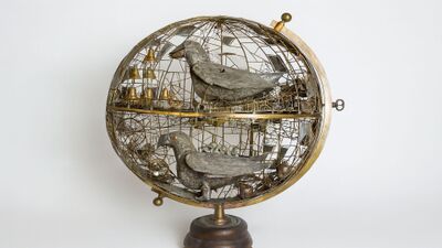 Im Paul Gugelmann Museum in Schönenwerd (5012, Kanton Solothurn) zeigt ein kunstvoll gestaltetes mechanisches Objekt zwei stilisierte Vögel in einem halbkugeligen Metallgerüst.