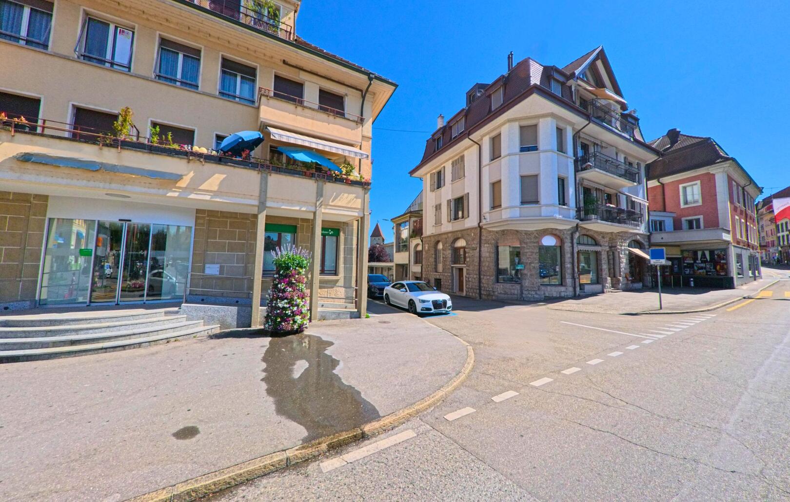 In Payerne (1530, Kanton Waadt) treffen sich an einer Strassenecke mehrere mehrstöckige Wohn- und Geschäftshäuser mit unterschiedlichen Fassadenstilen.