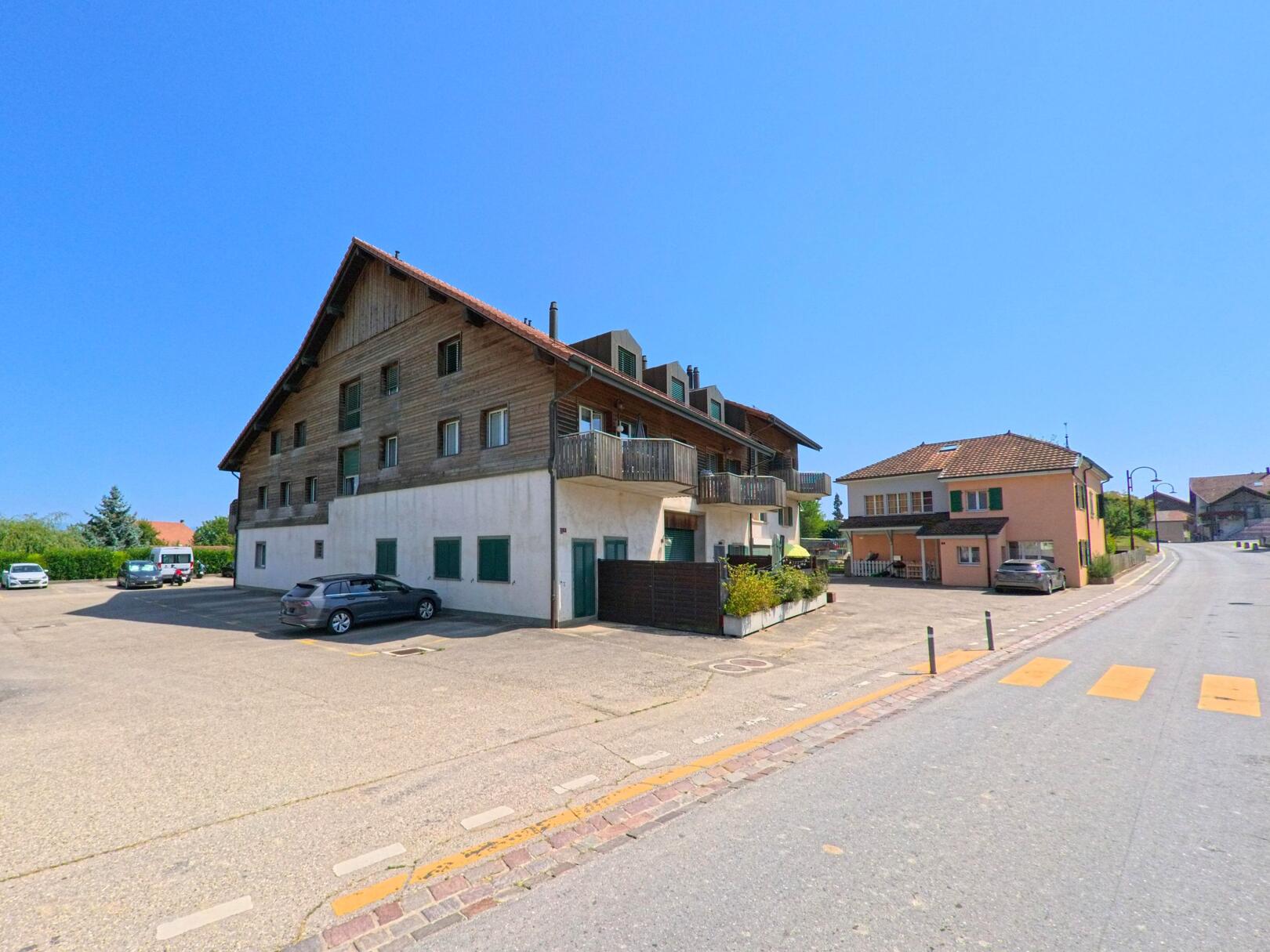 Ein traditionelles Wohnhaus mit Holzelementen und Balkonen praegt das Strassenbild von Penthereaz (1375, Kanton Waadt).