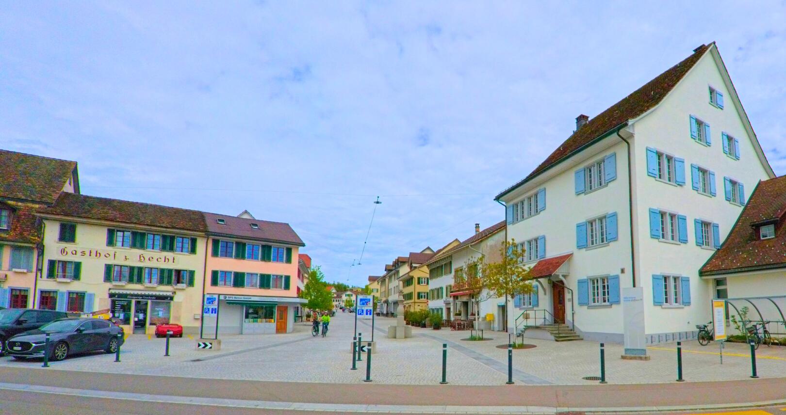 Im Zentrum von Pfäffikon mit der PLZ 8330 im Kanton Zürich reihen sich historische Gebäude mit Fensterläden entlang einer verkehrsberuhigten Pflasterstrasse.