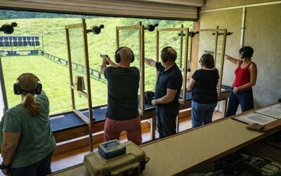 Mehrere Personen schiessen mit Pistolen auf Zielscheiben auf einem Schiessstand in Kerzers (3210, Kanton Freiburg) und zeigen Konzentration.