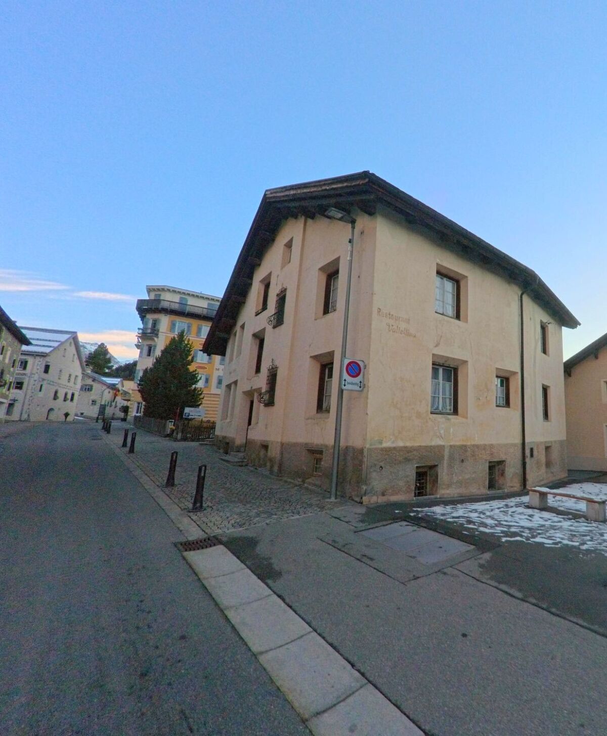 In einer ruhigen Seitengasse von Pontresina (7504, Kanton Graubünden) steht ein traditionelles Wohnhaus mit schlichter Fassade neben gepflasterten Gehwegen.